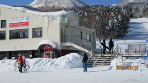 A building with a sign indicating it is a free rest area and a ramen corner. - Minshuku Mutsukari (Furano)