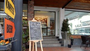 An outdoor seating area with a chalkboard menu, a coffee sign, and a beer sign. - Lao Silk Hotel (Vientiane)