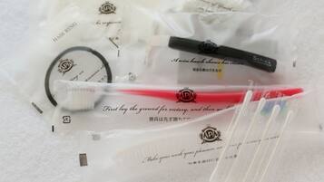 A collection of personal care items including a body sponge, hair ring, and a brush, all packaged in clear plastic with text and logos.