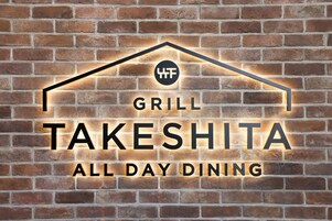 Un muro de ladrillo con un letrero de neón que dice "GRILL TAKESHITA ALL DAY DINING".
