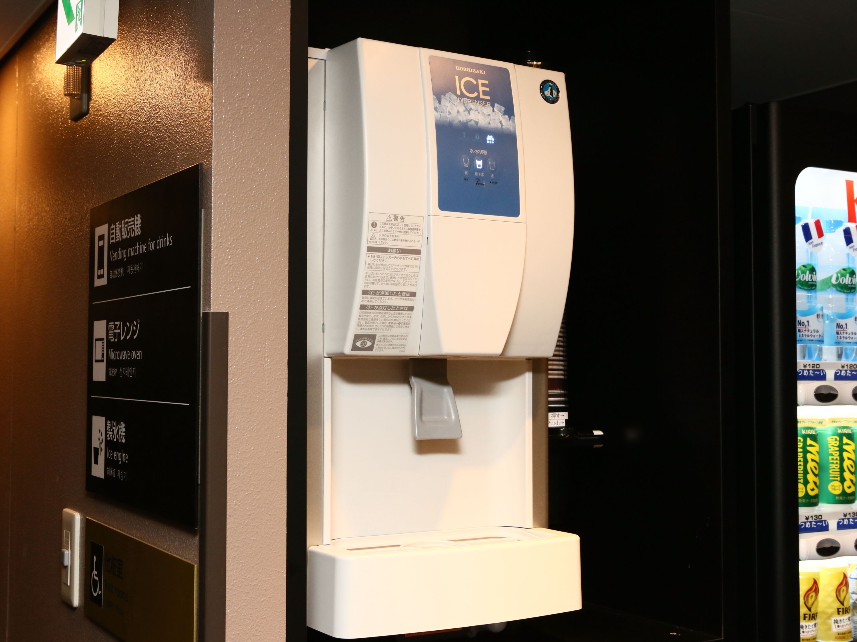 A vending machine for drinks and a microwave oven.