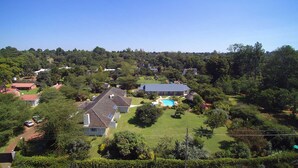 A residential area with houses, a swimming pool, and lush greenery.
