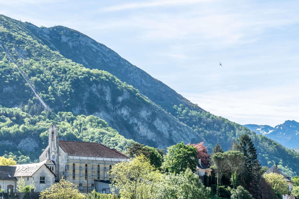 A mountainous landscape with a church and residential buildings.