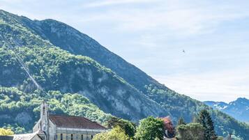 Un paysage montagneux avec une église et des immeubles d’habitation.