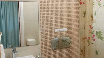 Een badkamer met een wastafel, toilet en douchegordijn.