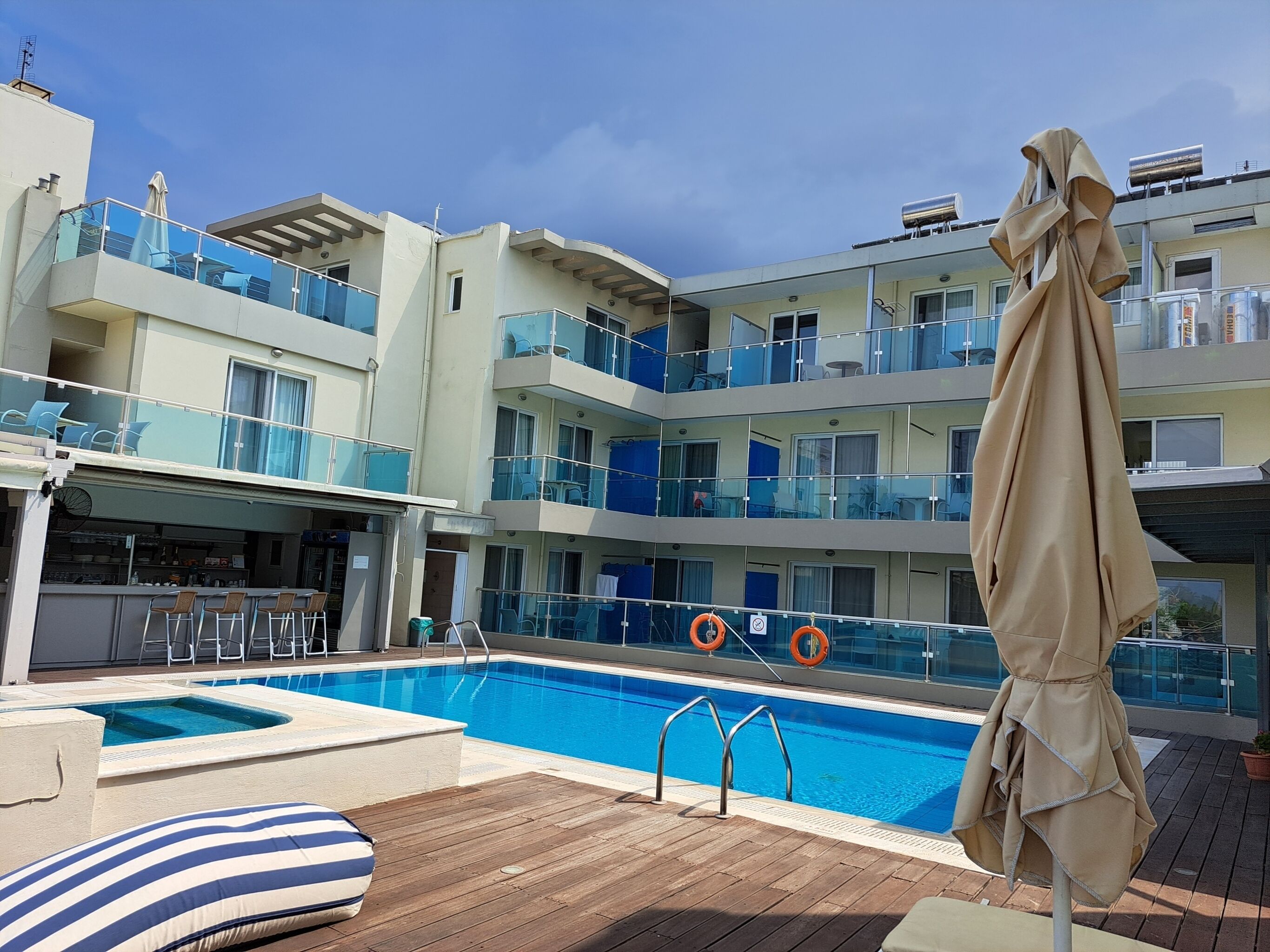 Une piscine sur le toit, avec un espace bar, plusieurs balcons et un coin salon abrité.