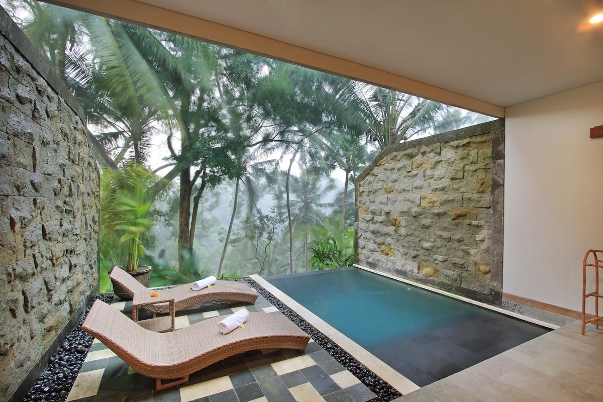 A private pool area with lounge chairs and a stone wall.