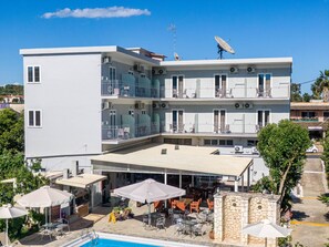 A multi-story hotel with balconies, outdoor seating, and a swimming pool. - Angela Hotel and Apartments (Corfu)