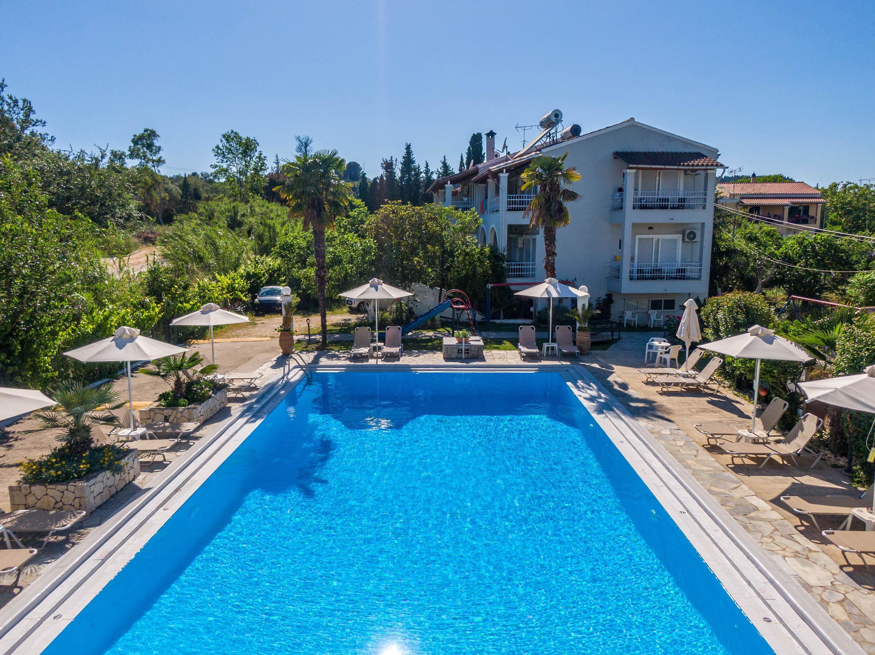 Una piscina al aire libre de temporada, sombrillas, tumbonas