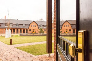 Een gebouw van baksteen met een binnentuin, een fontein en een pad.
