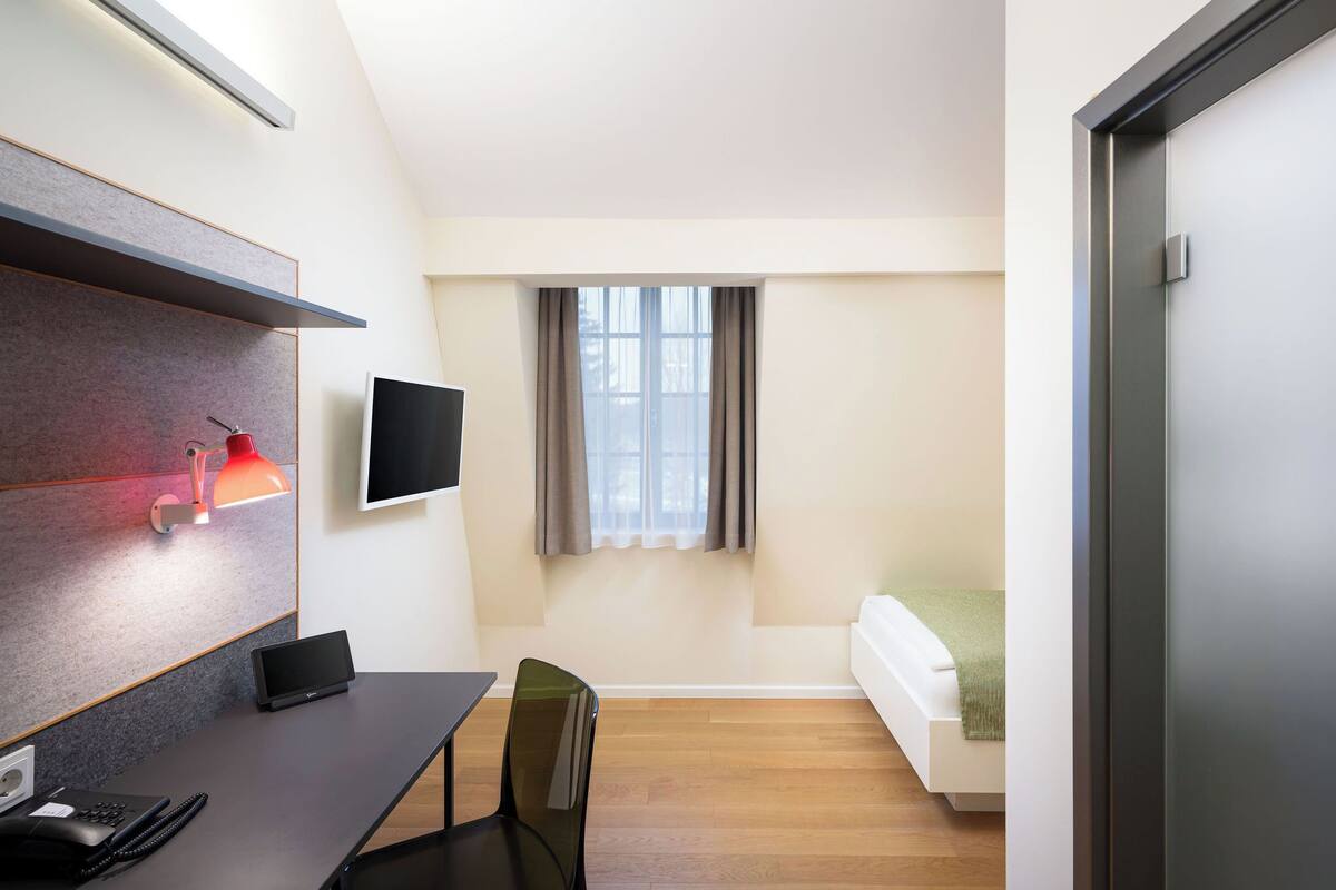 Una habitación moderna con escritorio, silla y cama.