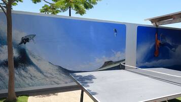 A ping pong table with a mural of a surfer riding a wave.