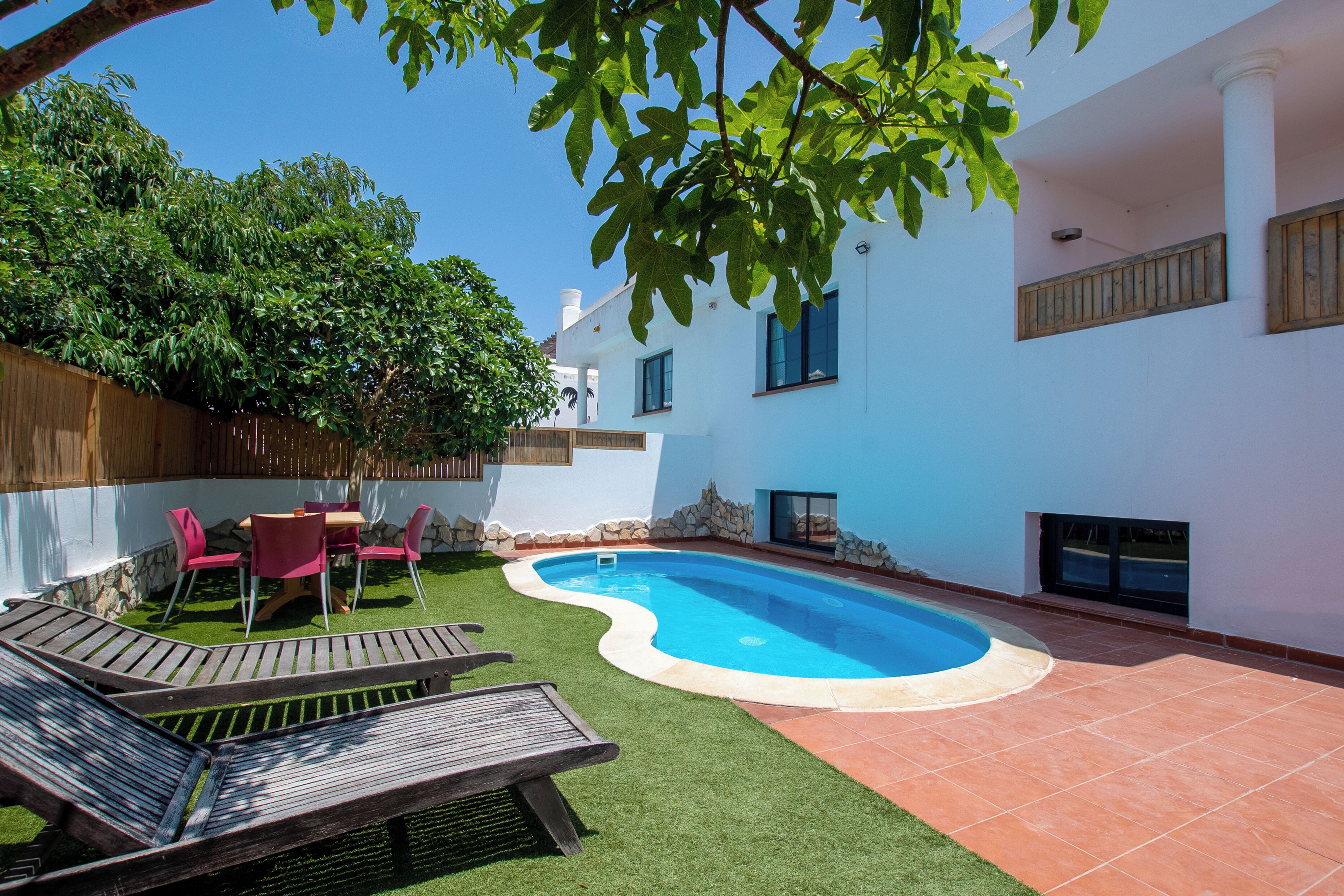 Un jardin avec une piscine, une terrasse en bois et un espace patio.