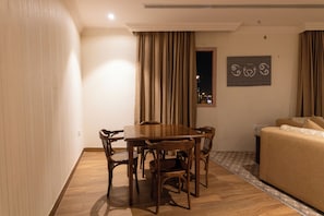 Een eethoek met een houten tafel en stoelen, een bank en een wanddecoratie met een patroon.