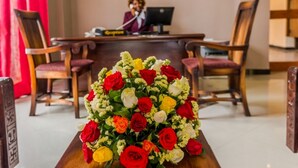 Un mostrador de recepción con un arreglo floral al frente.
