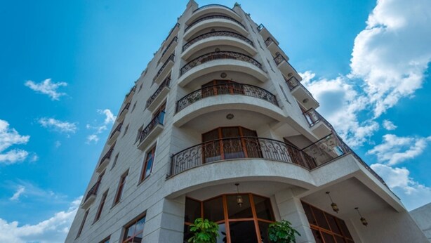 Un edificio de varios pisos con balcones y ventanas amplias.