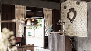 A room with a wooden reception desk, a clock on the wall, and a window with curtains. - ONCE (upon a time) Chiang Mai Boutique Home (Chiang Mai)
