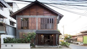 A two-story house with a wooden facade and a small porch. - ONCE (upon a time) Chiang Mai Boutique Home (Chiang Mai)