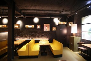 Ein Restaurantinneres mit Sitzecken, Tischen und an den Wänden angebrachter Kunstwerke.