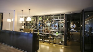 Een modern interieur met een receptiebalie, plantenrekken en hanglampen.