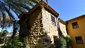A stone building with a yellow exterior and a balcony. - Casa Rural El Borbullón (Teror)