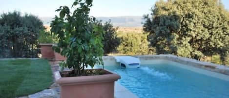 Een buitenzwembad, parasols voor strand/zwembad