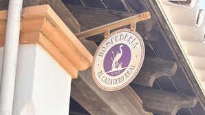 Una entrada de edificio con un letrero que dice 'HOSPEDERIA EL CAZADERO RURAL'.