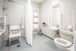 Un baño moderno con ducha, inodoro y lavamanos.