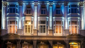 The Bishop's Gate Hotel facade at night with illuminated windows and columns, featuring the name 'Bishop's Gate Hotel' above the entrance. - Bishop's Gate Hotel (Londonderry)