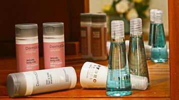 Variedad de productos para el cuidado de la piel sobre una superficie de madera, incluyendo botellas con la etiqueta 'Dermacare' y 'Hydro S.I.C.S'.
