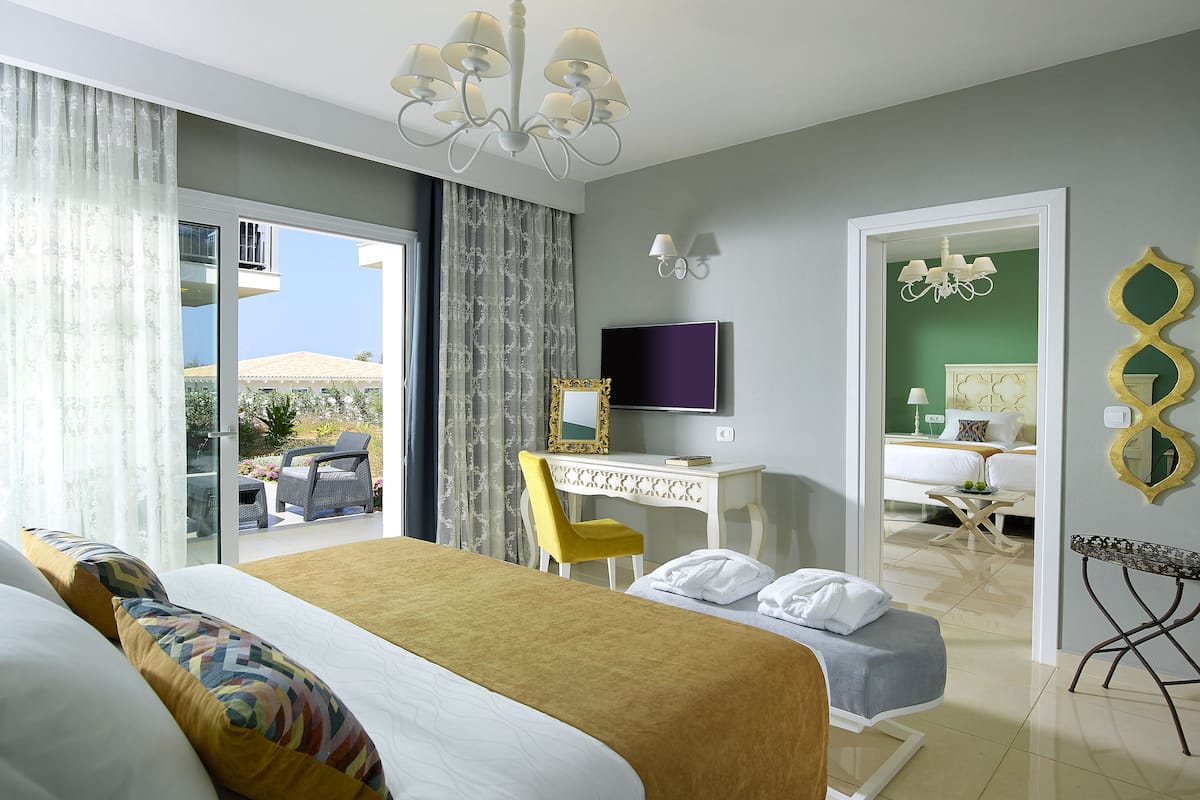 Habitación de hotel con una cama grande, un escritorio, un televisor y vistas al exterior.