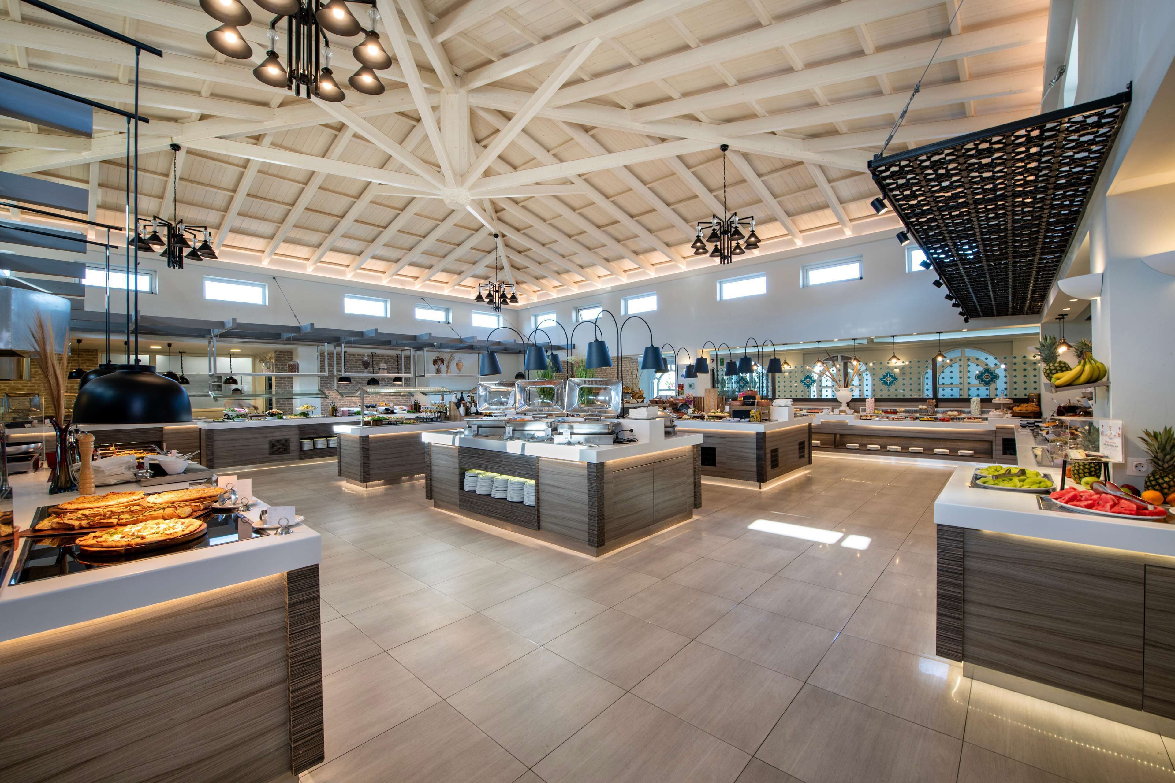 A spacious, well-lit kitchen area with multiple counters and hanging lights.