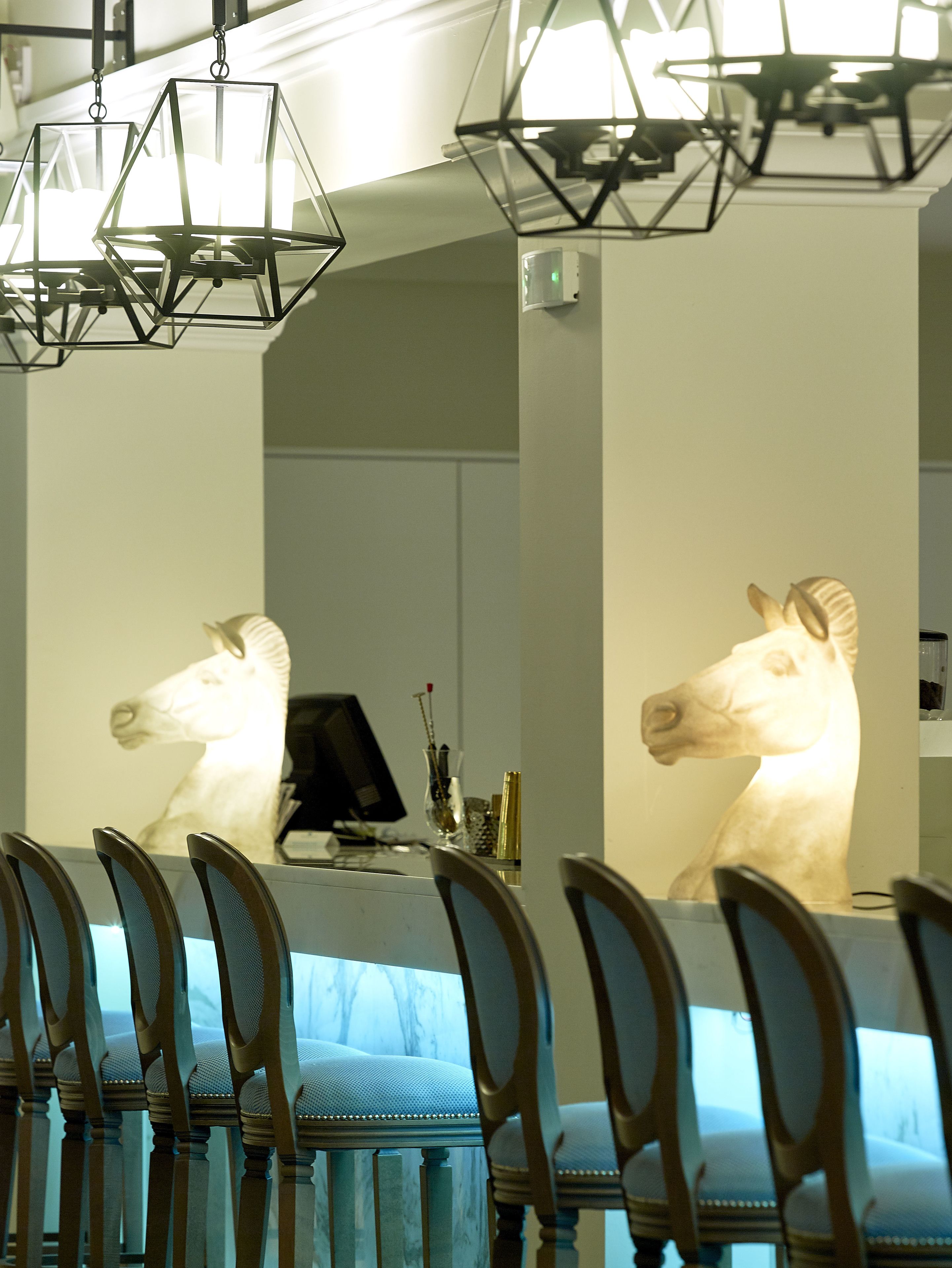 A dining area with a long table, chairs, and a horse head sculpture.