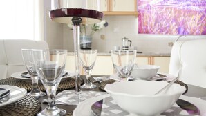 A dining table set with clear glassware, white plates, and a white bowl. - Flower Pot Complex (Preveza)
