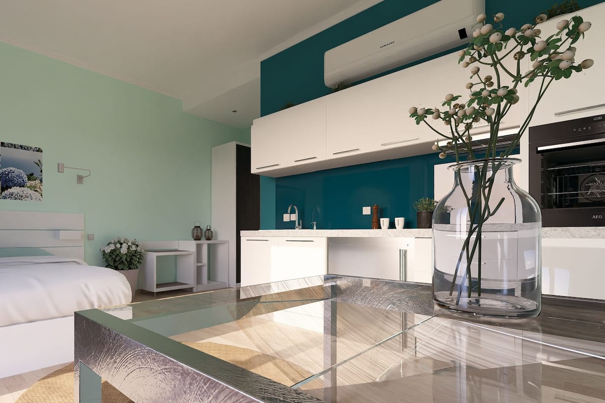 Un dormitorio moderno con una cama, mesitas de noche, una mesa de centro de vidrio y un florero con flores.