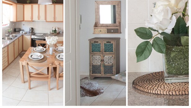 A modern kitchen with wooden cabinets, a dining area with a table set for two, and a decorative mirror above a cabinet. - Flower Pot Complex (Preveza)
