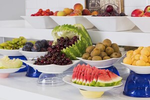 Un tavolo per buffet con diversi tipi di frutta e verdura.