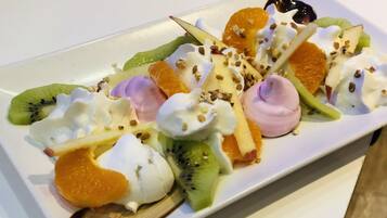 Ein Dessertteller mit verschiedenen Früchten und Schlagsahne.