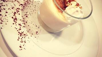 Een dessert met slagroom en een gekarameliseerde topping, geserveerd op een wit bord.