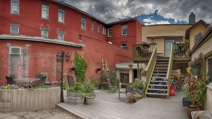 A courtyard with a wooden deck, outdoor seating, and potted plants. - Country Encounters (Coleman)