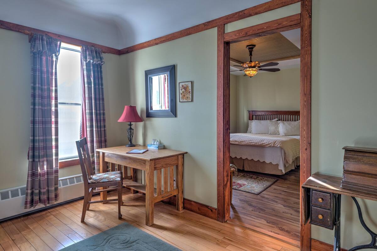 Una habitación con escritorio de madera, silla y cama.