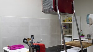 Una cocina con un tostador rojo, una tabla de cortar de madera y un recipiente rosa para utensilios.