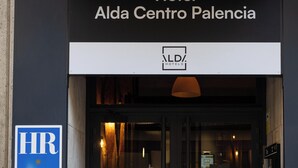 La entrada al Hotel Alda Centro Palencia, con un cartel que indica el nombre y el logotipo del hotel.