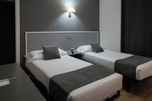 A hotel room with two beds, a nightstand, a lamp, and a desk with a chair. - Hotel Alda Centro Palencia (Palencia)