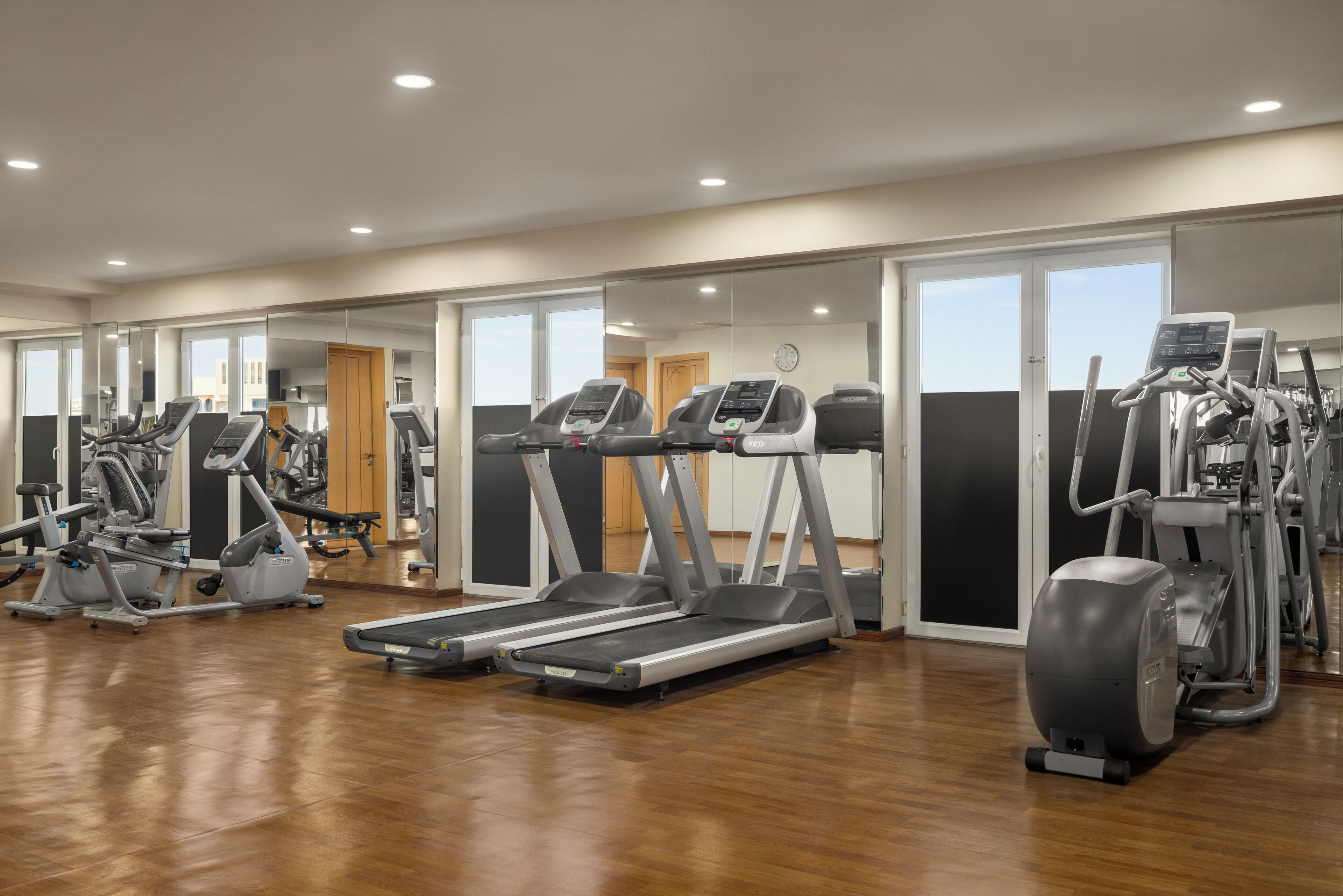 A gym with treadmills, elliptical machines, and other fitness equipment.