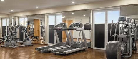 A gym with treadmills, elliptical machines, and other fitness equipment.