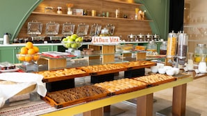 Um buffet de café da manhã com diversos alimentos e um letreiro escrito 'LA Dolce Vita'.