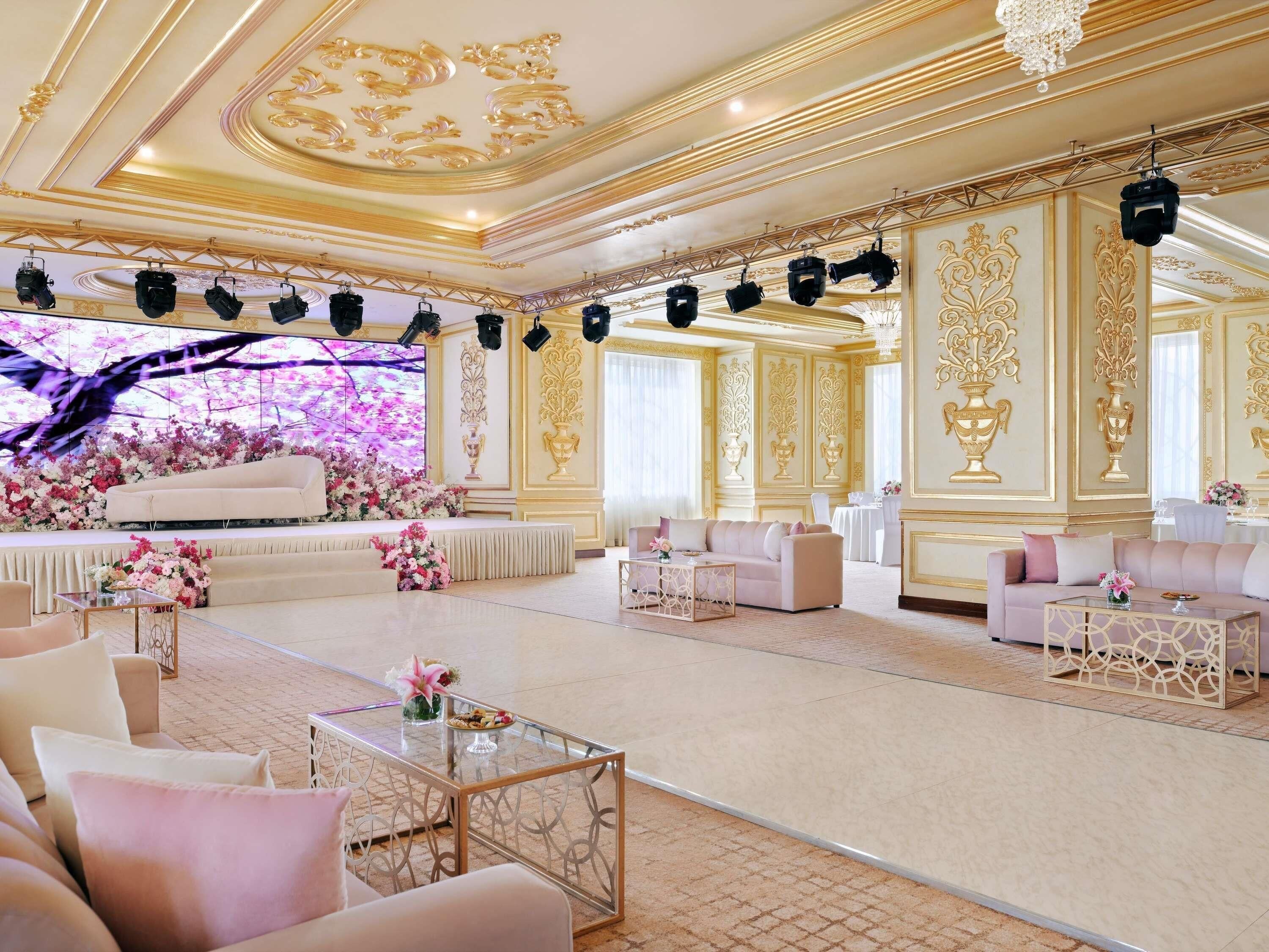 A luxurious room with a stage, elegant furniture, and ornate wall decorations.