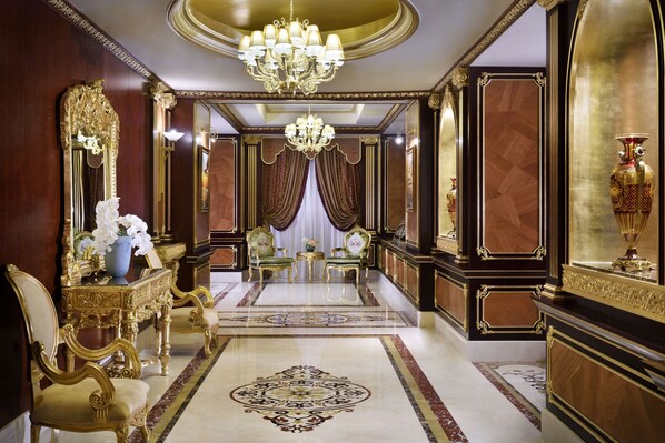Una habitación opulenta con una espectacular lámpara de araña, muebles ornamentados y un lujoso diseño de piso.