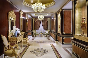 Una habitación opulenta con una espectacular lámpara de araña, muebles ornamentados y un lujoso diseño de piso.